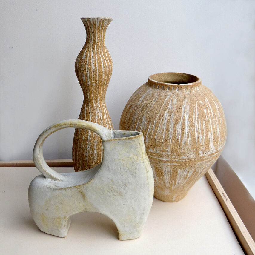 Trois vases en grès : deux vases en terre brut ocre avec trace d'engobe et un vase “animal” en blanc mat.